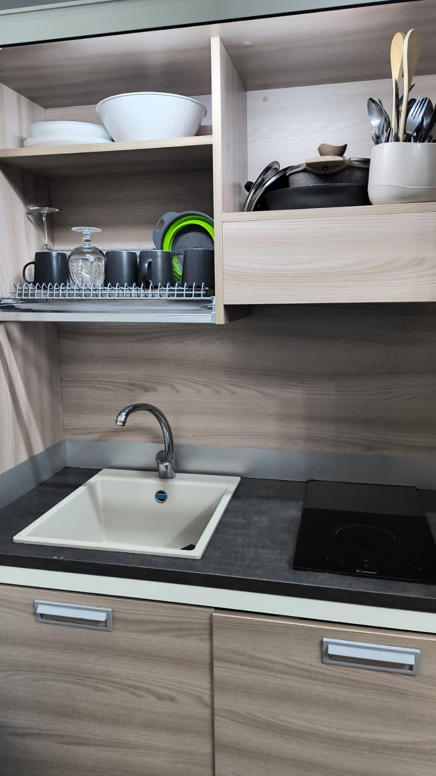 Cucina completamente attrezzata con piano a induzione e frigorifero