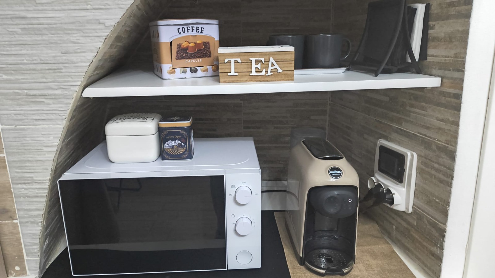 Fornetto e macchina del caffè in capsule nella cucina attrezzata